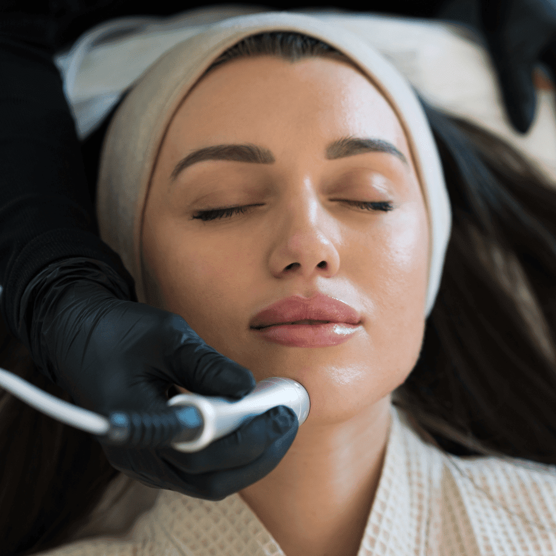 Woman receiving facial treatment with a handheld device at a spa.